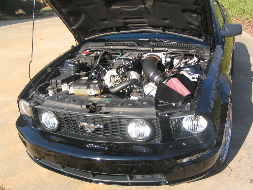 2007 Ford Mustang engine bay with supercharger and red air filter