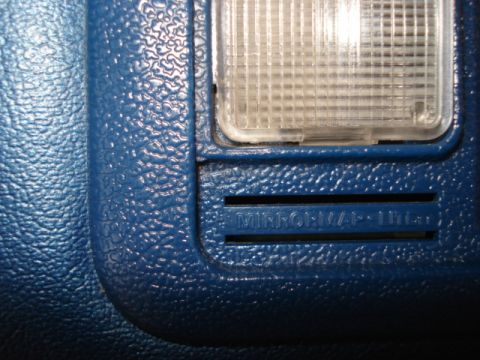 1979 Ford Bronco - Close-up of blue interior trim with a map light and embossed text.