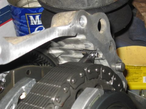 1990 Ford F-250 - Detailed view of an engine's internal timing chain and sprockets, with a metal bracket overhead.
