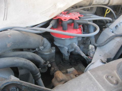 1990 Ford F-250 - Close-up of an engine's distributor cap and associated wiring, with visible 'MOTORCRAFT' hose text.