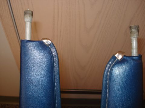 1979 Ford Bronco - Close-up of two blue upholstered parts, possibly interior trim pieces, with metal accents.