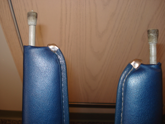 Two blue upholstered parts with chrome trim and metal rods extending from the top