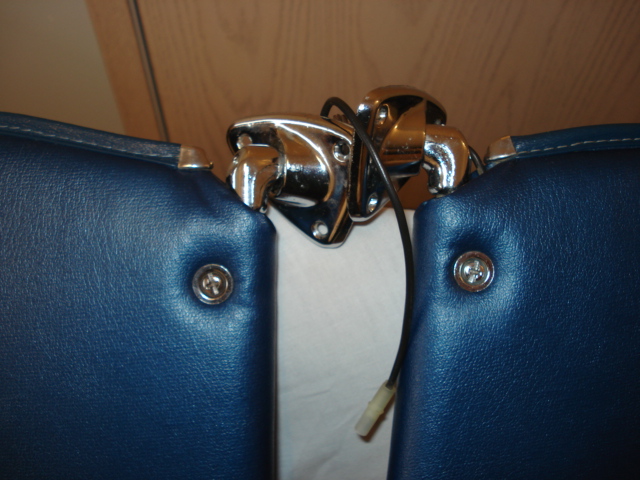 close-up of a chrome latch mechanism between two blue upholstered panels
