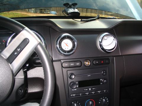 2007 Ford Mustang - Interior view of a 2007 Ford Mustang, showing the dashboard, steering wheel, and center console with a gauge and radio.