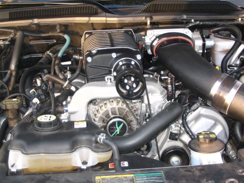 2007 Ford Mustang - Close-up view of a vehicle's engine bay, a prominent supercharger and associated components.