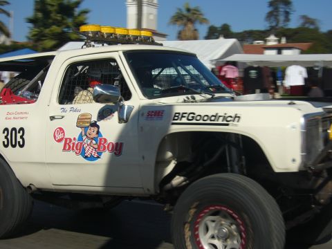 1986 Ford Bronco - Side view of a white square-body desert race truck numbered 303, wearing Bob's Big Boy and BFGoodrich decals, driver names Zach Churchill a…
