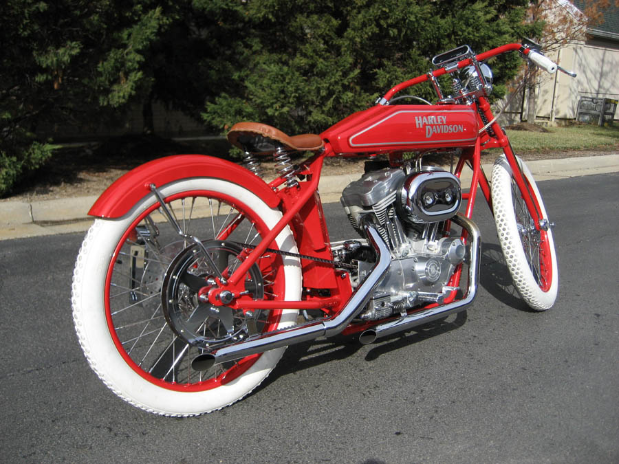 Red custom motorcycle with white wall tires and Harley-Davidson tank