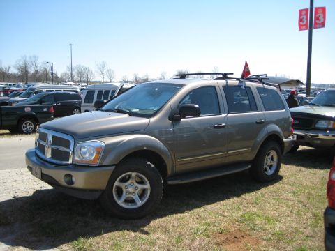 2004 Dodge Durango - A tan 2004 Dodge Durango SUV is parked on a grassy lot with other vehicles visible.