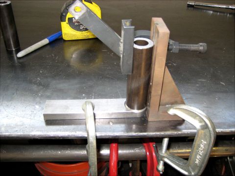 1996 Ford Bronco - A jig is set up to hold a metal tube for fabrication, with a tape measure and marker visible.