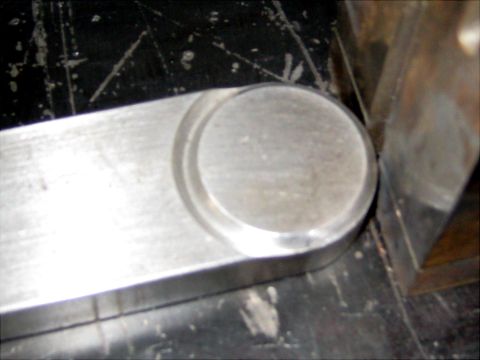 1996 Ford Bronco - Close-up view of a fabricated metal component with a rounded end and a circular recess.
