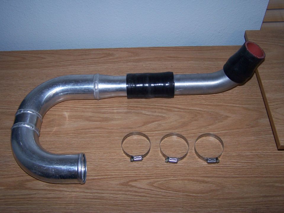 Aluminum intake pipe with black couplers and three hose clamps on a wooden surface
