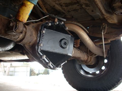 2000 Chevrolet Tahoe - Close-up view of a black aftermarket differential cover installed on a vehicle's rear axle.