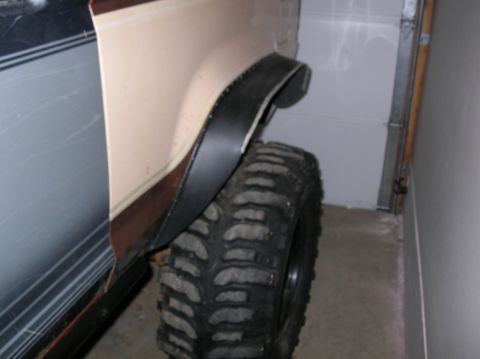 1985 Ford Bronco II - This photo shows a portion of a vehicle's fender and a large tire, likely in a garage.
