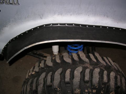 1985 Ford Bronco II - Close-up view of a vehicle's fender flare and tire, showing modifications.