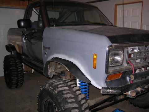 1985 Ford Bronco II - This heavily modified Ford truck features oversized tires and custom suspension components, with a primer-finished fender.