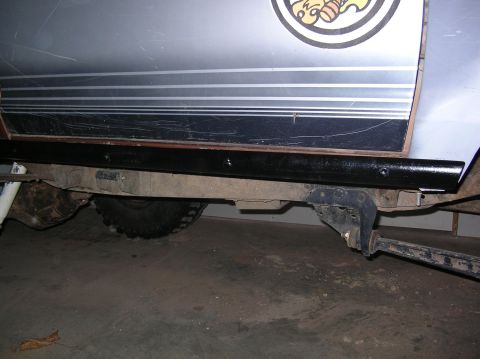 1985 Ford Bronco II - Close-up of a vehicle's side panel, showing the rocker trim and suspension components.