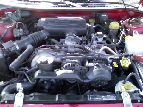 1997 Subaru Legacy - The engine bay of a red vehicle, showing the Subaru engine and associated components.