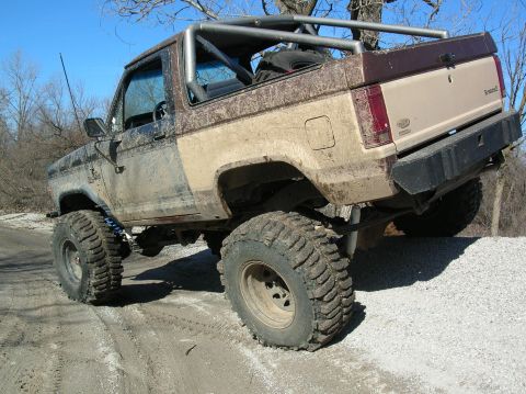 1985 Ford Bronco II - This modified Ford Bronco II is shown from a rear three-quarter angle, covered in mud.
