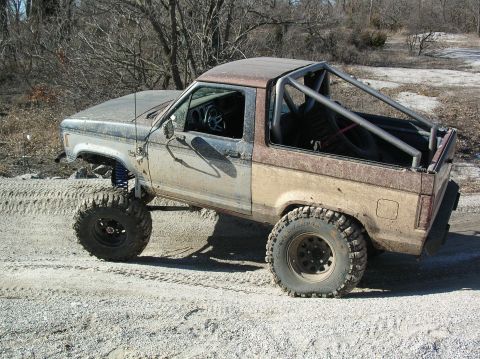 1985 Ford Bronco II - This modified 1983 Ford Bronco II is shown off-road with a roll cage and lifted suspension.