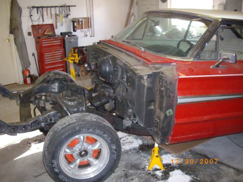 1964 Ford Galaxie - This vehicle is in a garage with its front end disassembled, showing the chassis and engine bay.