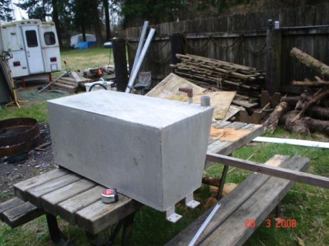 1990 Ford Bronco - A large, rectangular metal tank is placed on a picnic table, with a tape measure on the table surface.