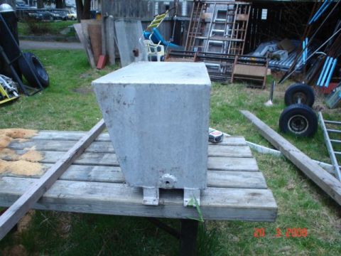 1990 Ford Bronco - A metal tank sits on a wooden table outdoors, with various items in the background.