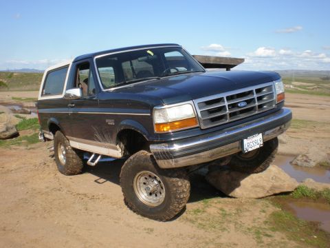 1993 Ford Bronco - Ford Bronco navigating rocky terrain with one wheel off the ground.