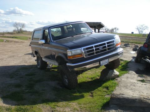 1993 Ford Bronco - This Ford Bronco is navigating an obstacle course, with one wheel perched on a large rock.