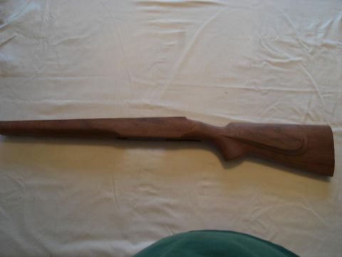 1991 Ford Bronco - A wooden rifle stock is shown against a white fabric surface.