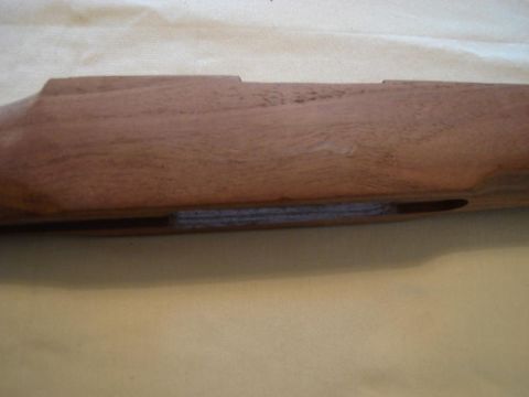 1991 Ford Bronco - A close-up view of a wooden gun stock, revealing a recessed section with layered material visible within.