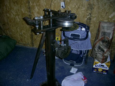 1978 Ford Bronco - A metal tube bender is shown in a workshop setting with various items in the background.