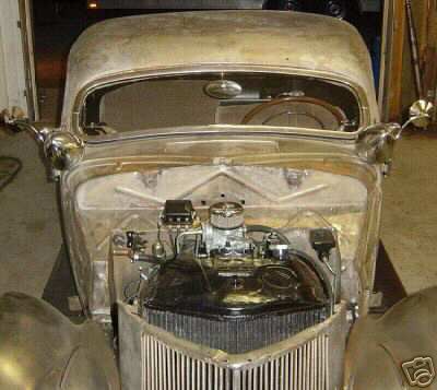 1936 Ford Coupe - Front view of a 1936 Ford Coupe project car, unpainted body, with engine exposed.