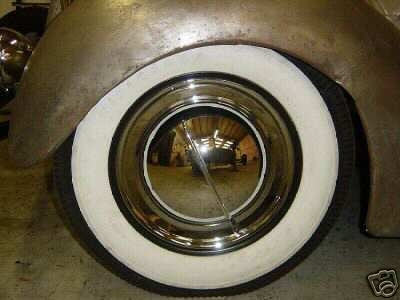 1936 Ford Coupe - Close-up of a 1936 Ford Coupe's side wheel, revealing whitewall tire and chrome hubcap.