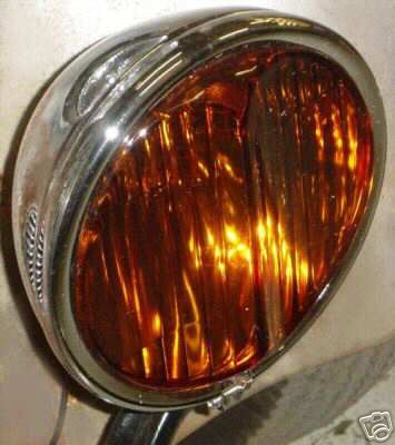 1936 Ford Coupe - Close-up of a vintage chrome headlight with an amber, ribbed lens.