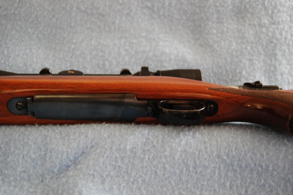 Side view of rifle action with scope and wooden stock