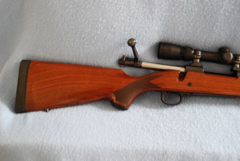 1991 Ford Bronco - Wooden stock rifle with a scope is shown from the side.