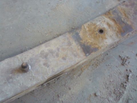 1992 Ford F-350 - A close-up view of a rusty leaf spring, showing a bolt and a hole, with the Supermotors.net logo in the corner.