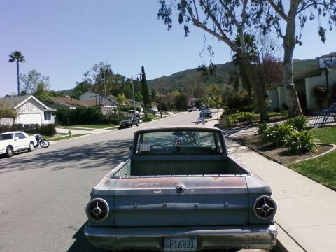 1964 Ford Ranchero - Rear view of a 1964 Ford Ranchero pickup truck on a sunny day in a residential neighborhood.