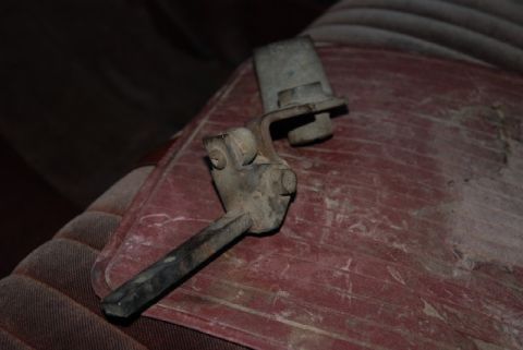 1987 Ford F-250 - A close-up view of a transfer case shifter lever resting on red patterned upholstery.