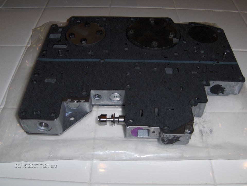 Transmission valve body with metal and plastic components. Date stamp reads 08/16/2007