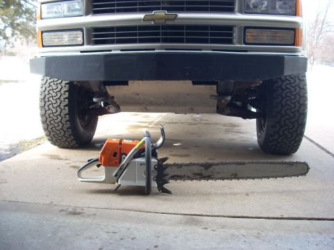 2000 Chevrolet Tahoe - Chainsaw placed in front of a Chevrolet truck's front end, showing off the vehicle's tires and bumper.
