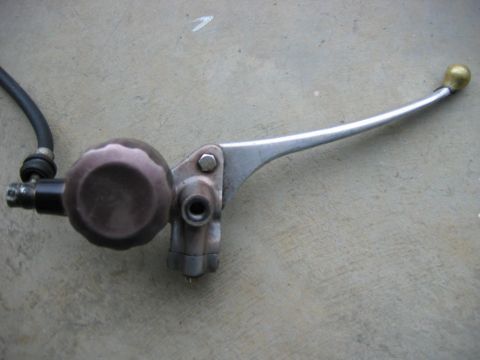 1985 Ford LTD Crown Victoria - This is a close-up view of a motorcycle's brake master cylinder assembly.