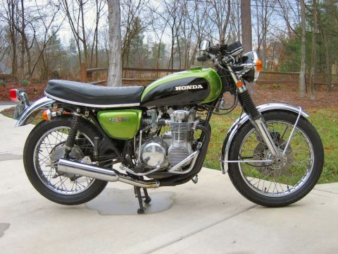 1985 Ford Crown Victoria LTD - Side view of a green and black Honda 400 Four motorcycle parked outdoors.