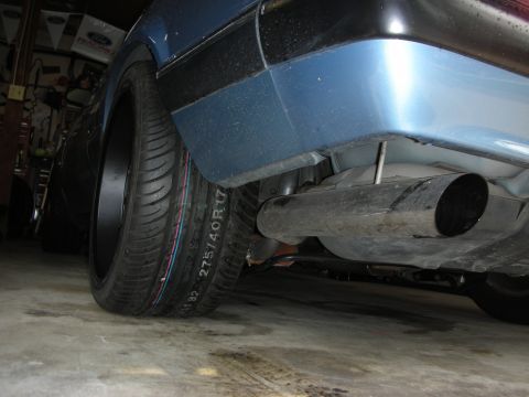 1990 Ford Mustang - Close-up view of a car's rear tire and exhaust system, showing tire size 275/40R17.