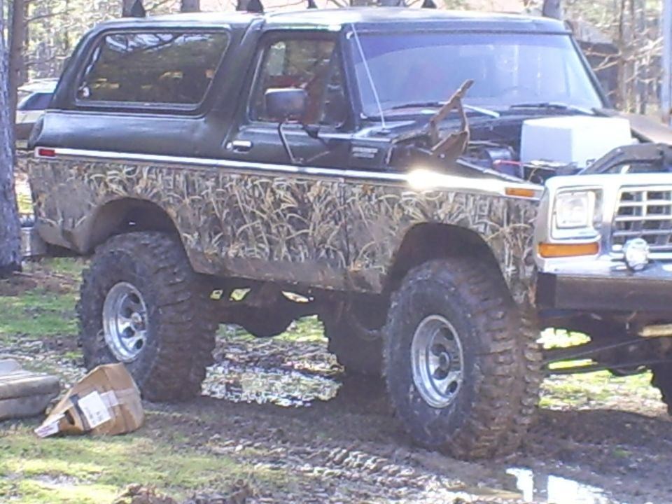 Black 1979 Ford Bronco with camouflage body wrap, 3/4 front view