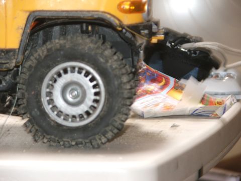 1996 Ford Bronco - Close-up view of a yellow vehicle's front corner, focusing on the tire and wheel assembly.