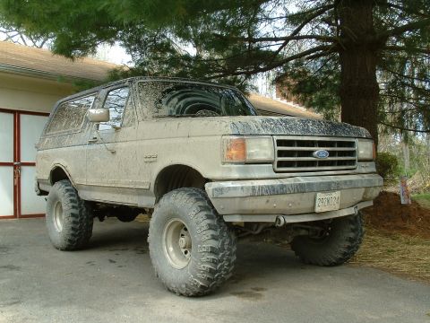 1991 Ford Bronco - This lifted 1991 Ford Bronco is covered in mud, suggesting recent off-road use.