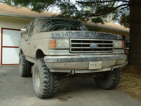 1991 Ford Bronco - This lifted 1992 Ford Bronco is heavily coated in mud, suggesting recent off-road use.