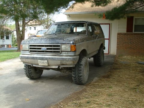 1991 Ford Bronco - This lifted 1991 Ford Bronco is parked in a driveway with a garage in the background.