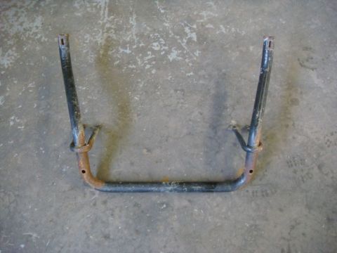 1996 Ford Bronco - A metal tubular bracket or mount, painted dark with surface rust near its lower bends, featuring bolt holes at the top ends and mid-section…